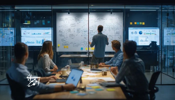 جلسه کوچینگ تیم در یک شرکت و توضیحات مدیر روی برد